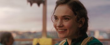 Movie still from “What's Love Got to Do with It?” (2022), directed by Shekhar Kapur – A person smiling for the camera; Close Up shot, Over the shoulder angle