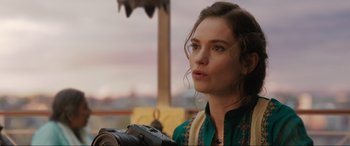 Movie still from “What's Love Got to Do with It?” (2022), directed by Shekhar Kapur – A beautiful young lady holding a camera in front of an outdoor setting; Close Up shot, Over the shoulder angle