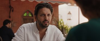 Movie still from “What's Love Got to Do with It?” (2022), directed by Shekhar Kapur – A person sitting at a table; Close Up shot, Over the shoulder angle