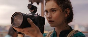 Movie still from “What's Love Got to Do with It?” (2022), directed by Shekhar Kapur – A woman holding up a camera with a microphone in front of her face; Close Up shot, Over the shoulder angle