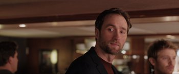 Movie still from “What's Love Got to Do with It?” (2022), directed by Shekhar Kapur – A person wearing a suit; Close Up shot, Over the shoulder angle