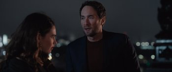 Movie still from “What's Love Got to Do with It?” (2022), directed by Shekhar Kapur – A man and a woman standing next to each other in front of lights; Close Up shot, Over the shoulder angle