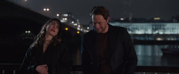 Movie still from “What's Love Got to Do with It?” (2022), directed by Shekhar Kapur – A man and a woman standing next to each other on a bridge; Medium shot, Over the shoulder angle