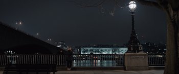 Movie still from “What's Love Got to Do with It?” (2022), directed by Shekhar Kapur – A woman standing on a bridge at night with a city in the background; Extreme Wide shot, High angle