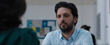 Movie still from “What's Love Got to Do with It?” (2022), directed by Shekhar Kapur – A person wearing a shirt; Close Up shot, Over the shoulder angle