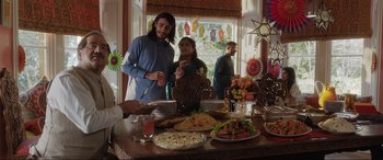 Movie still from “What's Love Got to Do with It?” (2022), directed by Shekhar Kapur – A man and a woman standing in front of a table full of food; Wide shot, High angle