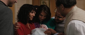 Movie still from “What's Love Got to Do with It?” (2022), directed by Shekhar Kapur – A group of people standing next to a baby; Medium shot, High angle