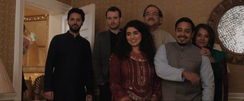 Movie still from “What's Love Got to Do with It?” (2022), directed by Shekhar Kapur – A group of men and a woman standing next to each other; Medium shot, High angle