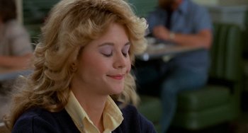 Movie still from “When Harry Met Sally...” (1989), directed by Rob Reiner – A woman with blonde curly hair is sitting in a room; Close Up shot, Low angle