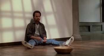Movie still from “When Harry Met Sally...” (1989), directed by Rob Reiner – A man sitting on the ground holding a remote control; Wide shot, High angle