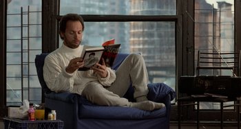 Movie still from “When Harry Met Sally...” (1989), directed by Rob Reiner – A man sitting on top of a blue couch reading a book; Medium shot, High angle