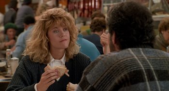Movie still from “When Harry Met Sally...” (1989), directed by Rob Reiner – A woman sitting at a table with a sandwich in front of a man; Medium shot, Over the shoulder angle