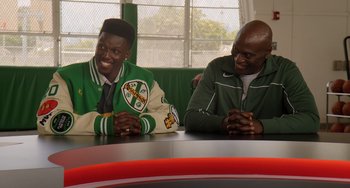 Movie still from “White Men Can't Jump” (2023), directed by Calmatic – A couple of men sitting next to each other at a table; Medium shot, Over the shoulder angle