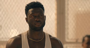 Movie still from “White Men Can't Jump” (2023), directed by Calmatic – A person wearing a tank top; Close Up shot, Over the shoulder angle