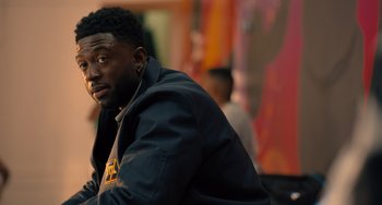 Movie still from “White Men Can't Jump” (2023), directed by Calmatic – A person wearing a jacket; Close Up shot, Over the shoulder angle