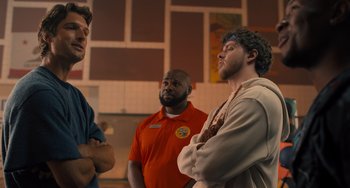 Movie still from “White Men Can't Jump” (2023), directed by Calmatic – A group of men standing next to each other in a room; Medium shot, Over the shoulder angle