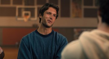 Movie still from “White Men Can't Jump” (2023), directed by Calmatic – A man in a blue shirt is looking at something; Close Up shot, Over the shoulder angle