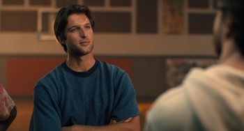 Movie still from “White Men Can't Jump” (2023), directed by Calmatic – A man with his arms crossed looking off into the distance; Close Up shot, Over the shoulder angle