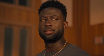 Movie still from “White Men Can't Jump” (2023), directed by Calmatic – A person wearing a necklace; Close Up shot, Over the shoulder angle