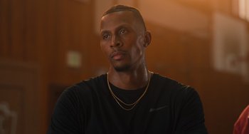Movie still from “White Men Can't Jump” (2023), directed by Calmatic – A person wearing a black shirt; Close Up shot, Low angle