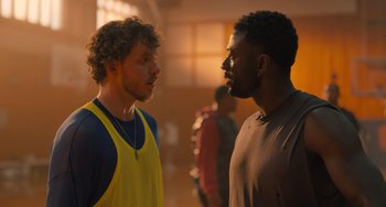 Movie still from “White Men Can't Jump” (2023), directed by Calmatic – Two men standing next to each other in a room; Close Up shot, Over the shoulder angle