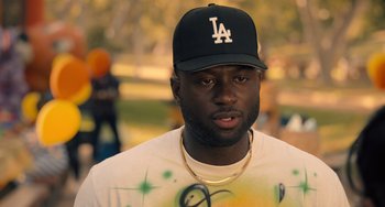 Movie still from “White Men Can't Jump” (2023), directed by Calmatic – A man in a baseball hat and a white shirt; Close Up shot, Over the shoulder angle
