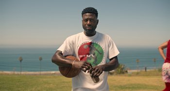 Movie still from “White Men Can't Jump” (2023), directed by Calmatic – A man holding a basketball in his hands; Medium shot, Low angle
