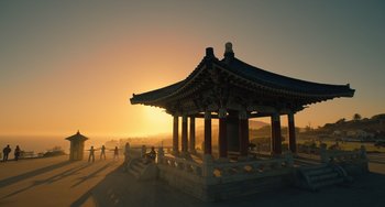 Movie still from “White Men Can't Jump” (2023), directed by Calmatic – A gazebo is shown at sunset on the beach; Extreme Wide shot, High angle