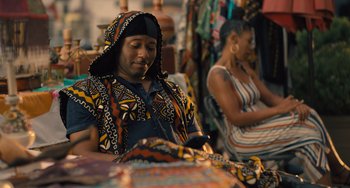 Movie still from “White Men Can't Jump” (2023), directed by Calmatic – A man sitting in front of a woman holding a cell phone; Medium shot, Over the shoulder angle