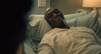 Movie still from “White Men Can't Jump” (2023), directed by Calmatic – A man laying in a hospital bed with his eyes wide open; Close Up shot, High angle