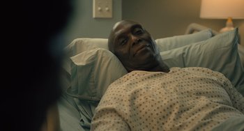 Movie still from “White Men Can't Jump” (2023), directed by Calmatic – A man laying in a hospital bed in a hospital room; Close Up shot, High angle