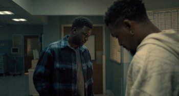 Movie still from “White Men Can't Jump” (2023), directed by Calmatic – Two young men standing in a room next to each other; Medium shot, Over the shoulder angle