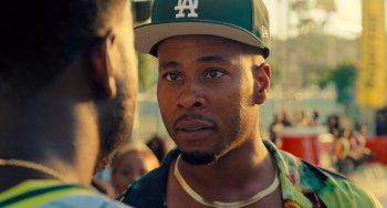 Movie still from “White Men Can't Jump” (2023), directed by Calmatic – A person wearing a hat; Close Up shot, Over the shoulder angle