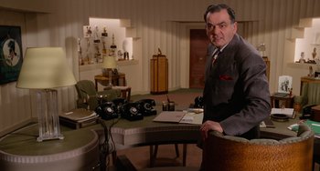 Movie still from “Who Framed Roger Rabbit” (1988), directed by Robert Zemeckis – An older man in a suit and tie sitting at a table; Medium shot, High angle