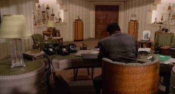 Movie still from “Who Framed Roger Rabbit” (1988), directed by Robert Zemeckis – A man sitting at a table in front of a laptop computer; Wide shot, High angle