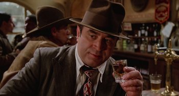 Movie still from “Who Framed Roger Rabbit” (1988), directed by Robert Zemeckis – A man wearing a hat and holding a shot glass; Close Up shot, Low angle