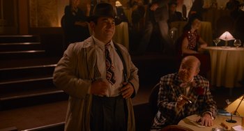 Movie still from “Who Framed Roger Rabbit” (1988), directed by Robert Zemeckis – A man wearing a hat and a tie standing in front of a crowd; Medium shot, Over the shoulder angle