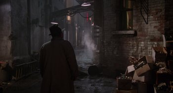 Movie still from “Who Framed Roger Rabbit” (1988), directed by Robert Zemeckis – A man in a trench coat and hat standing in the middle of an alleyway; Wide shot, Over the shoulder angle