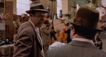 Movie still from “Who Framed Roger Rabbit” (1988), directed by Robert Zemeckis – A man in a suit and a hat talking to another man in a suit and a hat; Medium shot, Over the shoulder angle