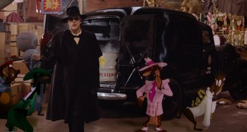 Movie still from “Who Framed Roger Rabbit” (1988), directed by Robert Zemeckis – A man in a black coat and hat standing next to an animated character; Wide shot, Low angle