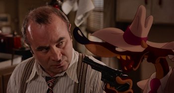 Movie still from “Who Framed Roger Rabbit” (1988), directed by Robert Zemeckis – A man in a tie holding a gun pointed at him; Close Up shot, Over the shoulder angle