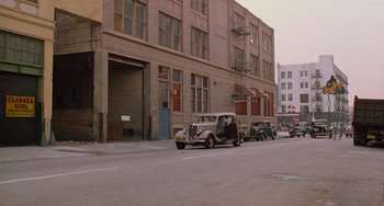 Movie still from “Who Framed Roger Rabbit” (1988), directed by Robert Zemeckis – An old car is driving down the street in front of a building; Extreme Wide shot, High angle
