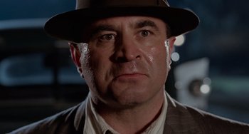 Movie still from “Who Framed Roger Rabbit” (1988), directed by Robert Zemeckis – A person wearing a suit and a hat; Close Up shot, Low angle