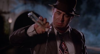 Movie still from “Who Framed Roger Rabbit” (1988), directed by Robert Zemeckis – A man in a suit and tie holding a glass; Close Up shot, Low angle