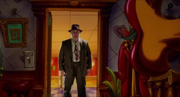 Movie still from “Who Framed Roger Rabbit” (1988), directed by Robert Zemeckis – A man in a suit and tie standing in front of a doorway; Wide shot, Low angle