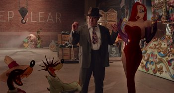 Movie still from “Who Framed Roger Rabbit” (1988), directed by Robert Zemeckis – A man in a suit and hat standing next to a statue of liberty; Wide shot, Over the shoulder angle