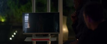 Movie still from “Wifelike” (2022), directed by James Bird – A man sitting in front of a computer monitor; Medium shot, Over the shoulder angle