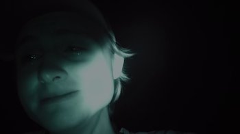 Movie still from “Wildcat” (2022), directed by Melissa Lesh – A person with a light shining on their face; Extreme Close Up shot, High angle
