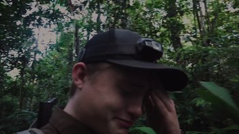 Movie still from “Wildcat” (2022), directed by Melissa Lesh – A young man wearing a black hat with a light on his head; Close Up shot, High angle