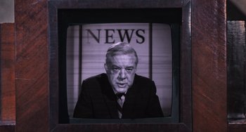 Movie still from “Willy Wonka & the Chocolate Factory” (1971), directed by Mel Stuart – An older man in a suit and tie in front of a news sign; Close Up shot, Low angle